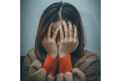 Woman depressed holding her hand to cover face